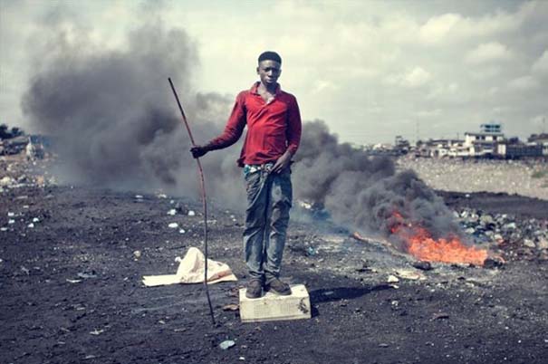 Ο 21χρονος John Mahama εισπνέει τα καμένα υλικά
